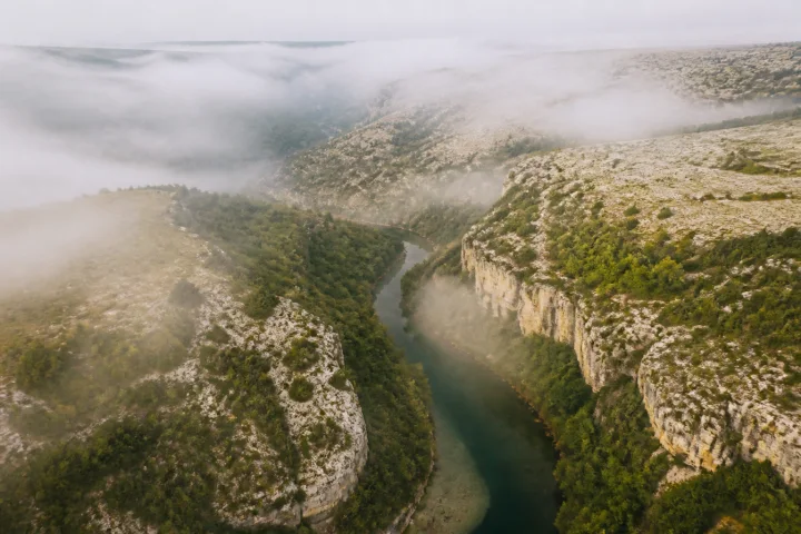 Morning mist lifting over a limestone river valley